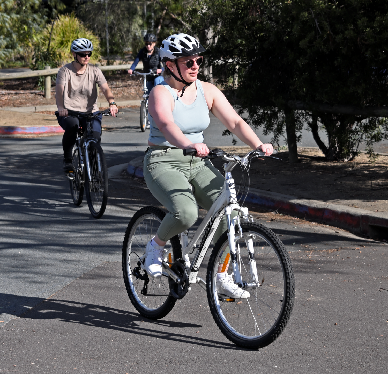 An adult Cycle Well participant practising riding while other learners follow behind