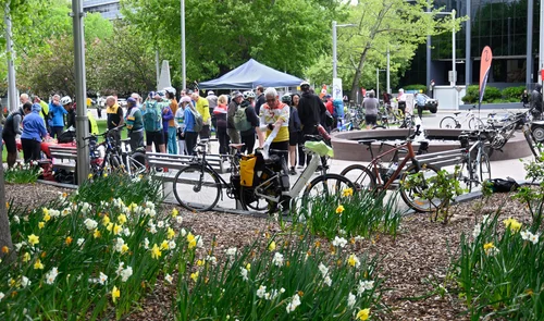 Riders gathering beside the garden beds at the 2026 Ride2Work breakfast