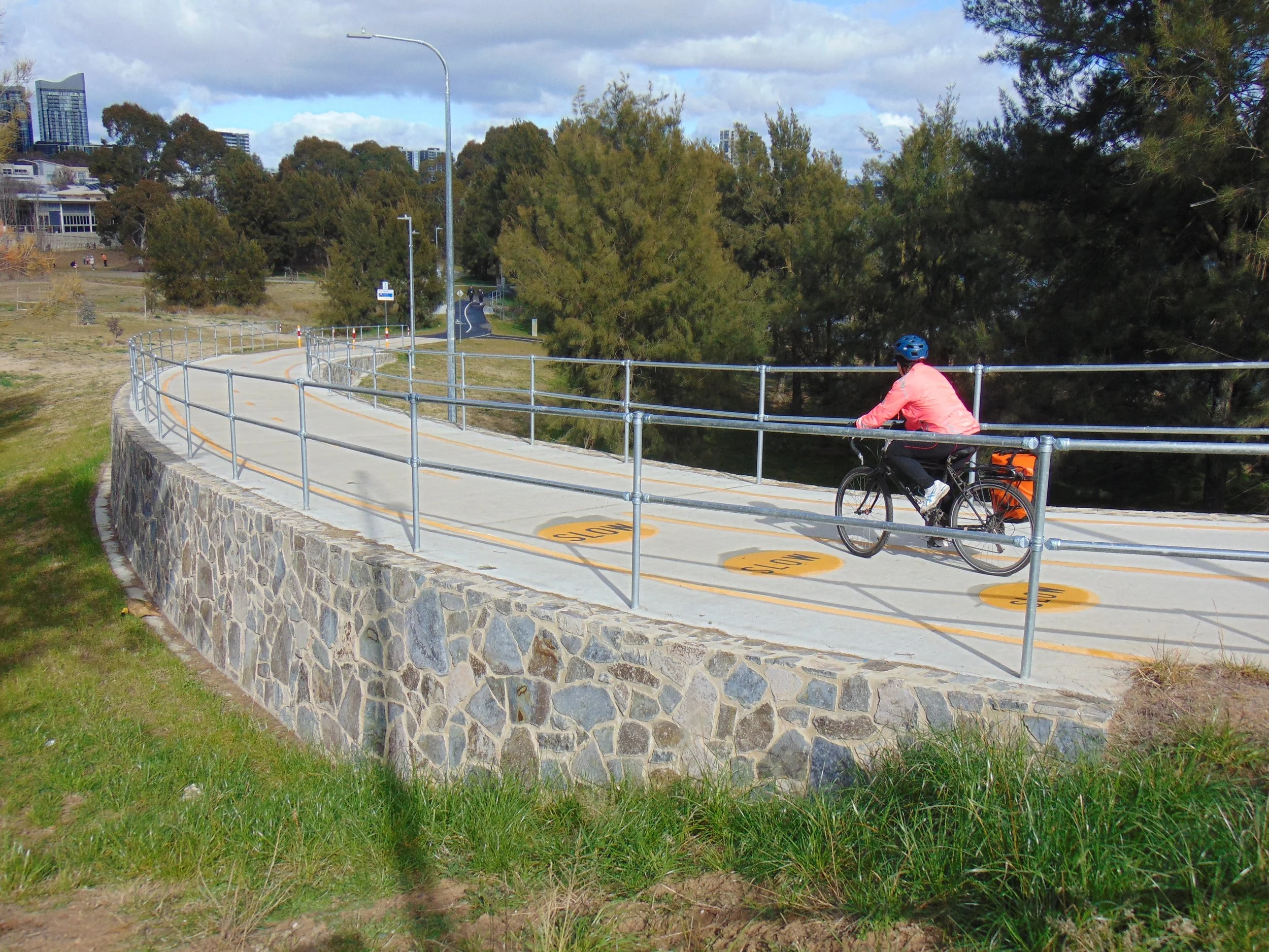 Cyclist riding on a shared path beside Lake Ginninderra