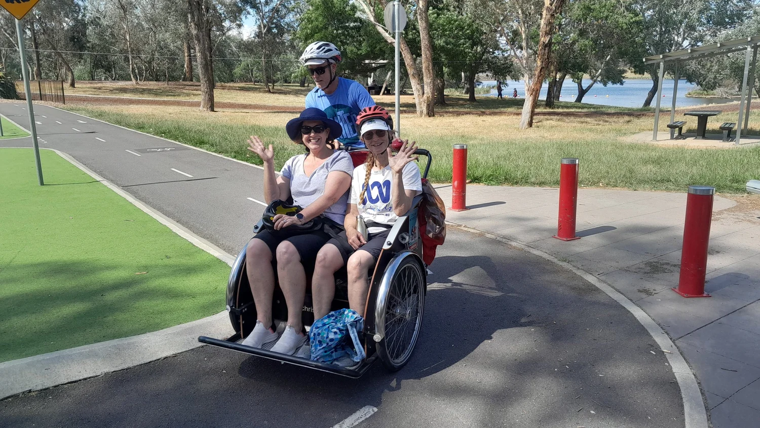 Passengers smiling during a trishaw ride on a Canberra path
