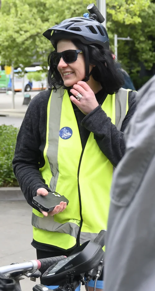 A smiling Ride2Work volunteer wearing a helmet and high-visibility vest
