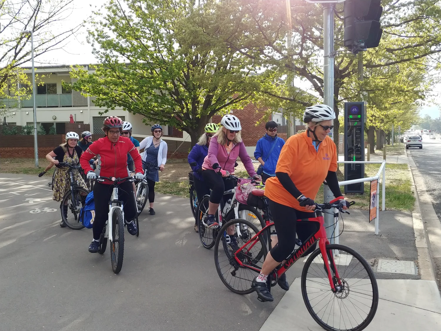 A group of people riding bicycles through a city intersection