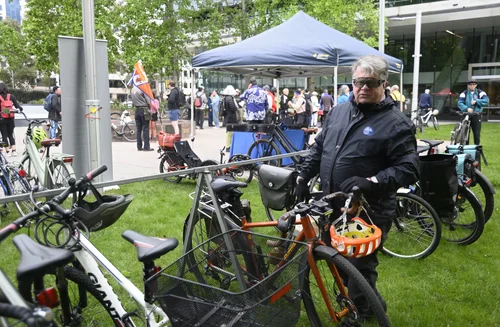 A rider standing with their bicycle and colourful helmet at Veterans Park