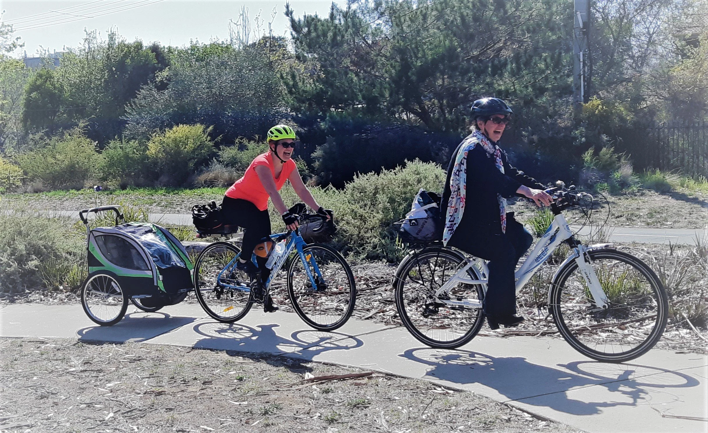 Two Pedal Power riders standing with their bikes