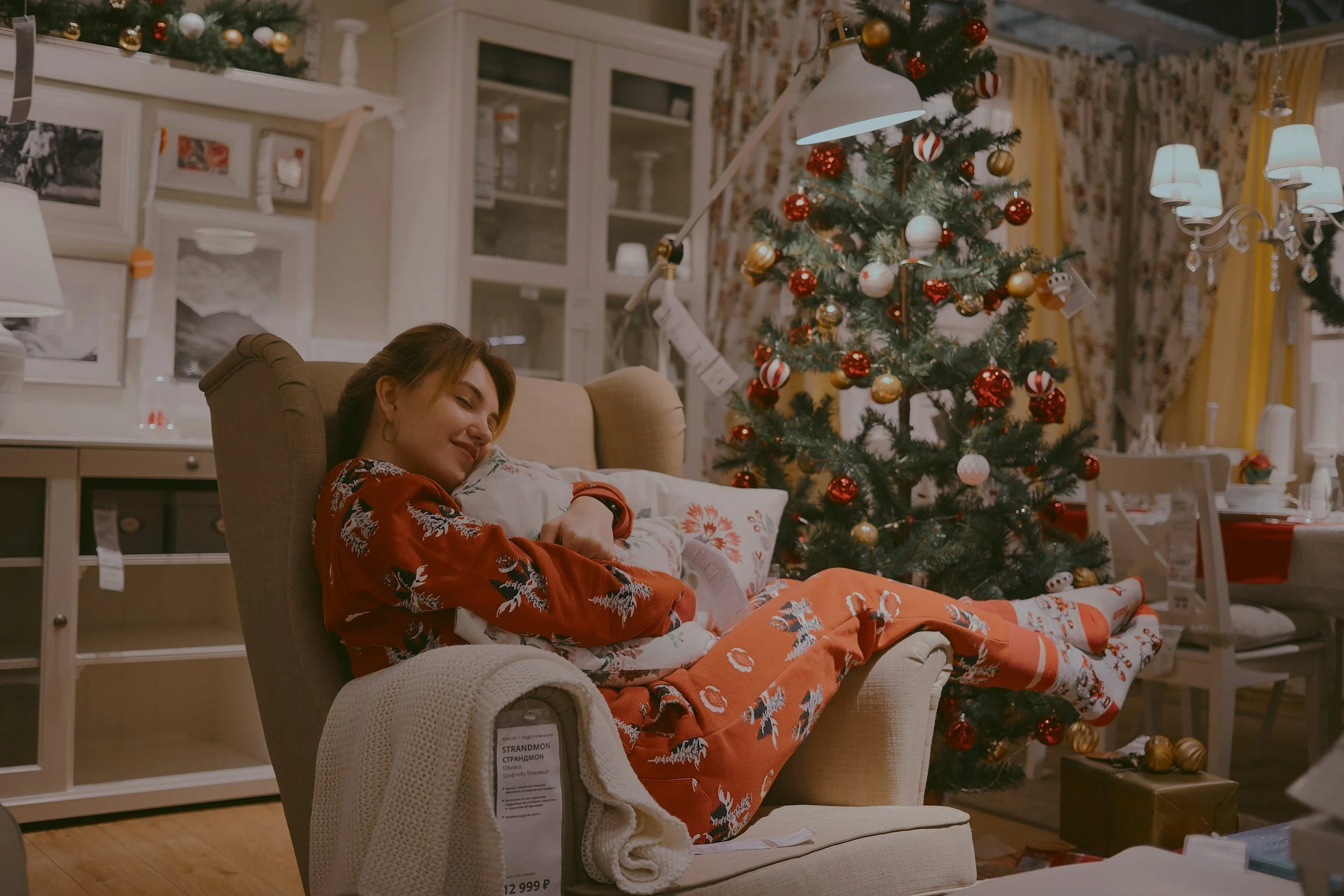 Woman on chair in pyjamas and Christmas tree