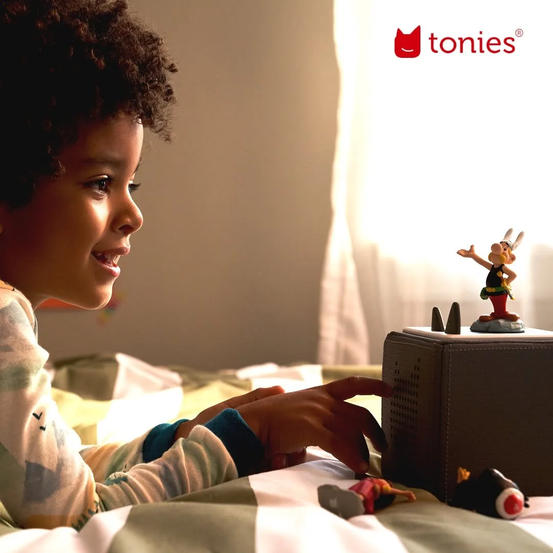 Un enfant joue dans sa chambre avec une tonie box audio dont la figurine représente Asterix