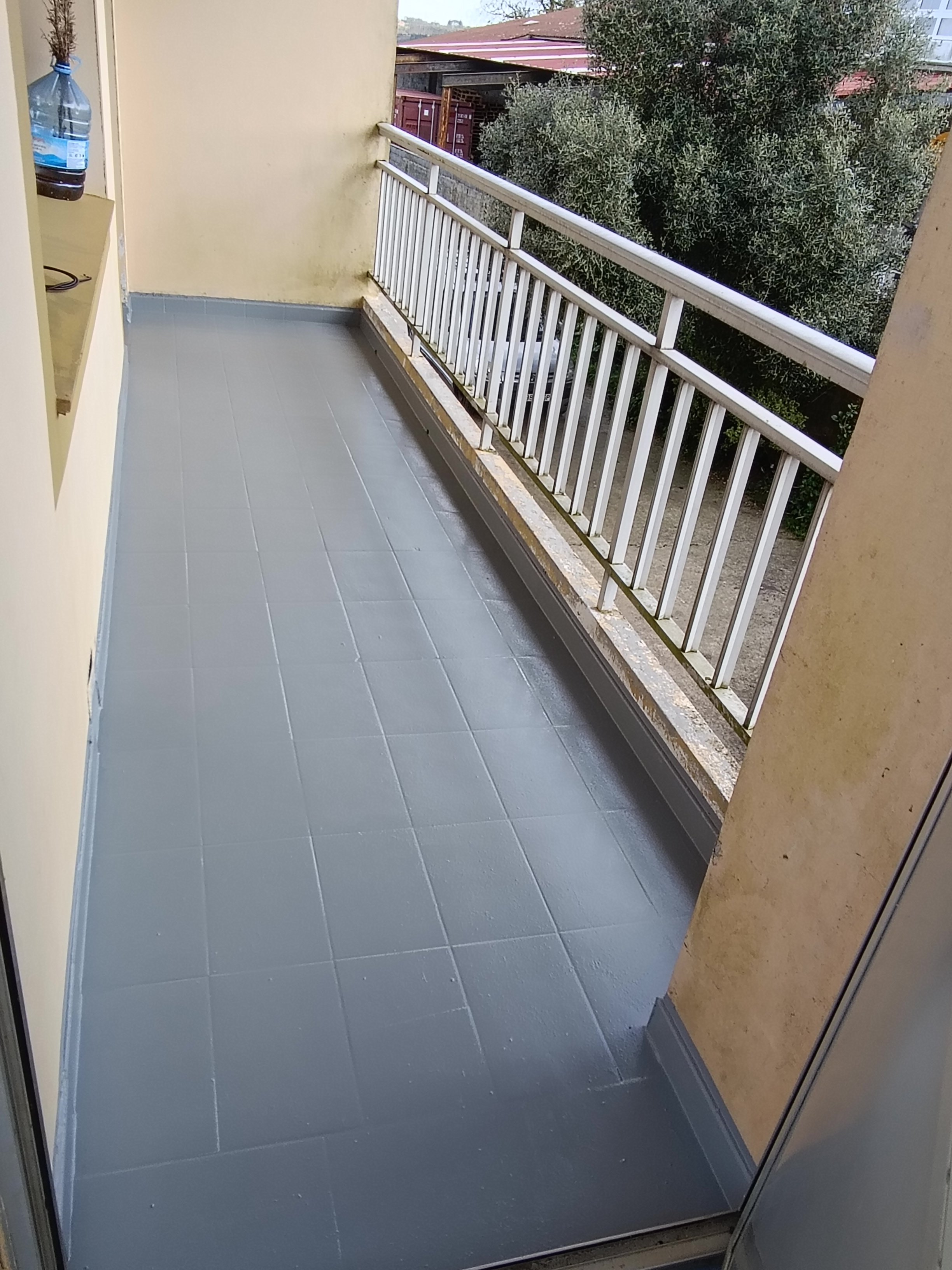 Terraza con paredes amarillas y barandilla blanca. 