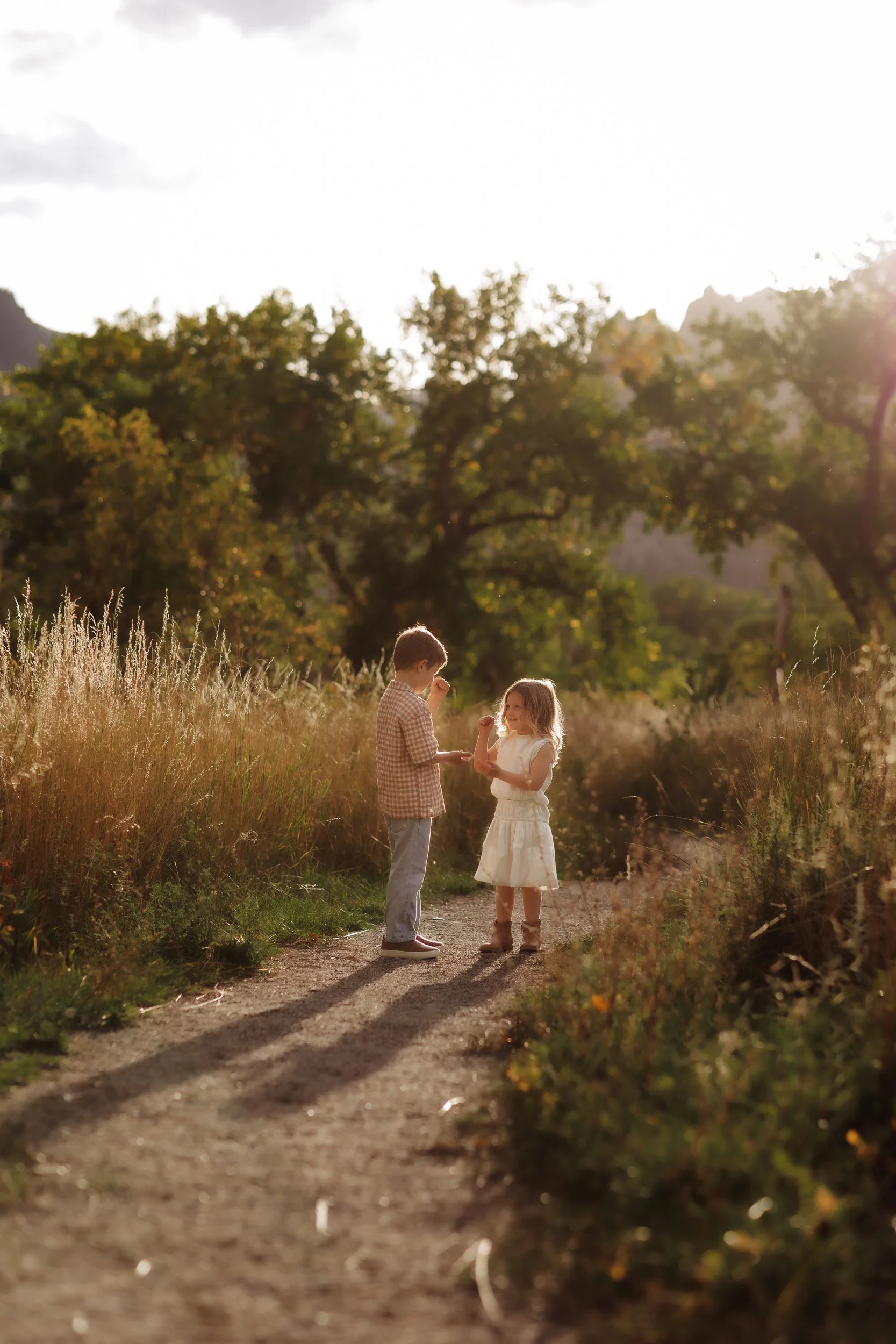 Two young children playing together outdoors in early fall at South Mesa Trailhead