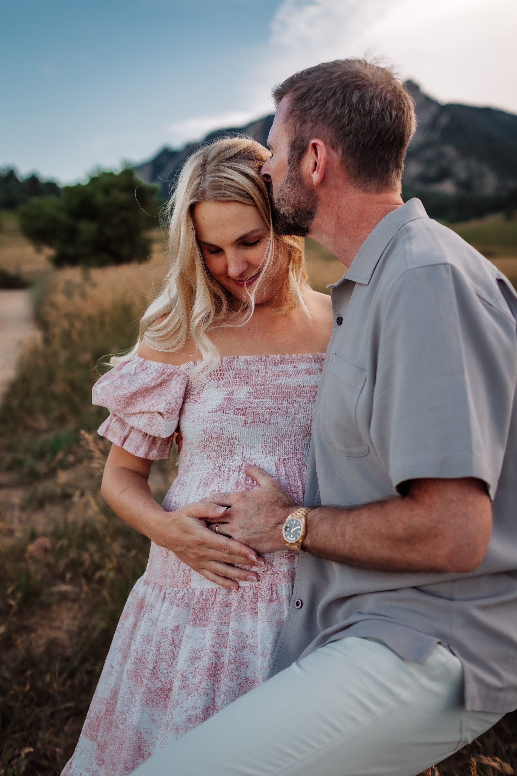 Intimate moment of Pekabu and David embracing in the grassy fields of Boulder, CO