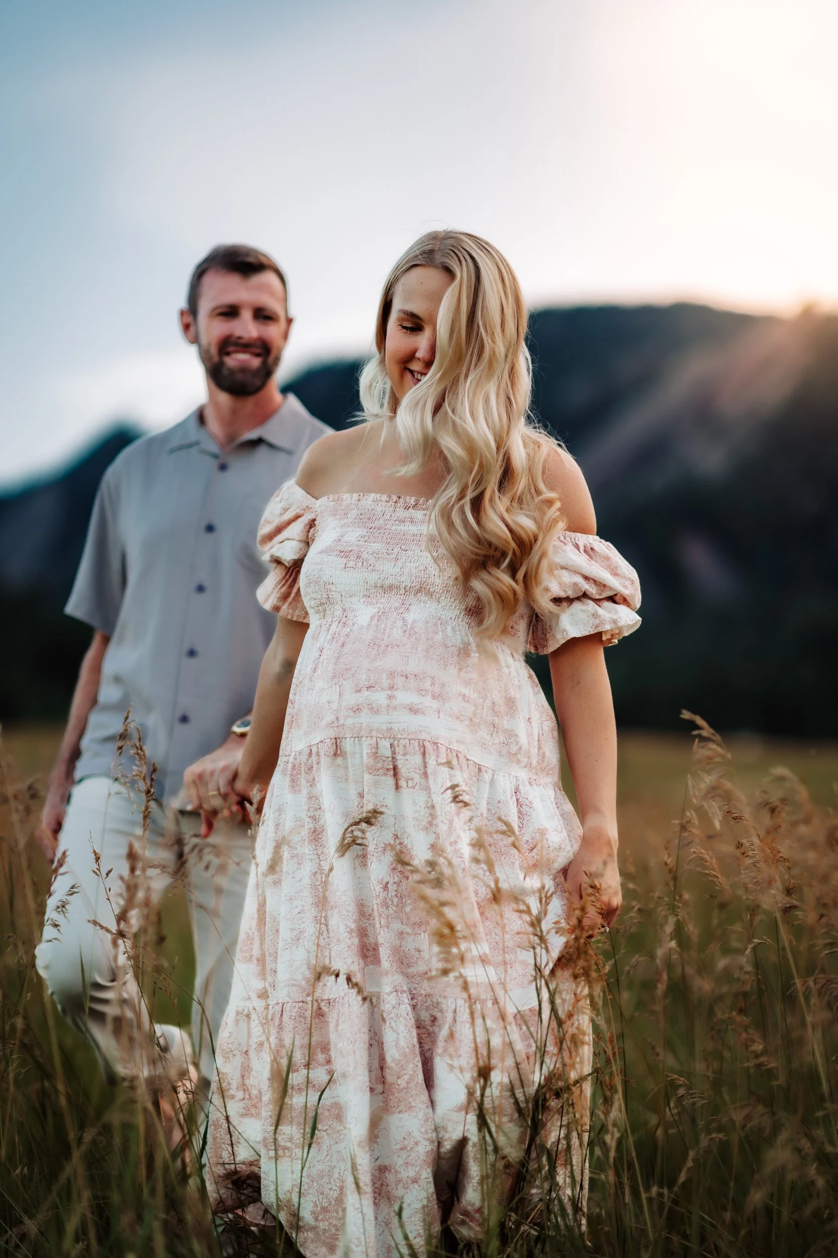 Couple walking along a flat path at Chautauqua Park, enjoying a calm maternity moment