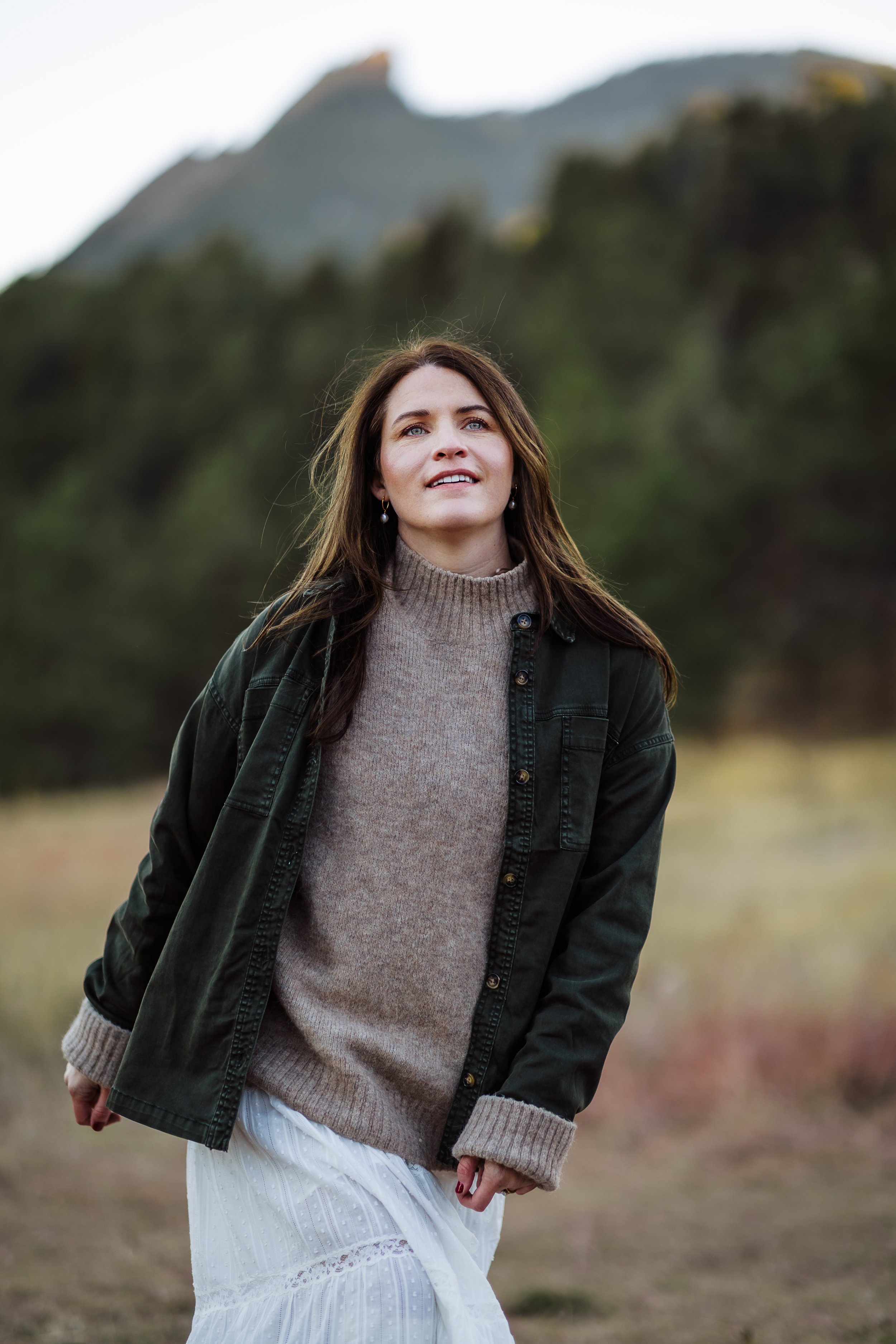 Young woman walking outside in a field for her causal and down-to-earth headshot