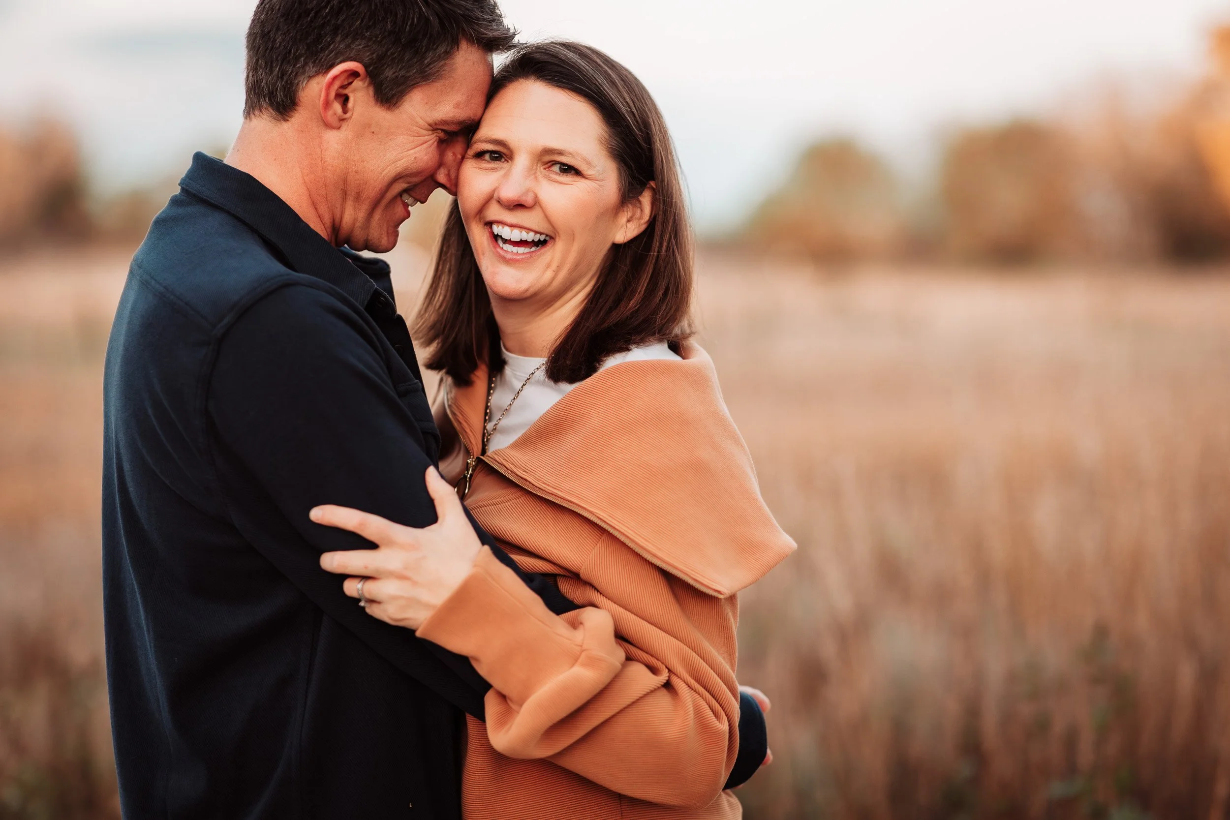 mom and dad getting cozy during fall family session at bobolink trail in boulder, co