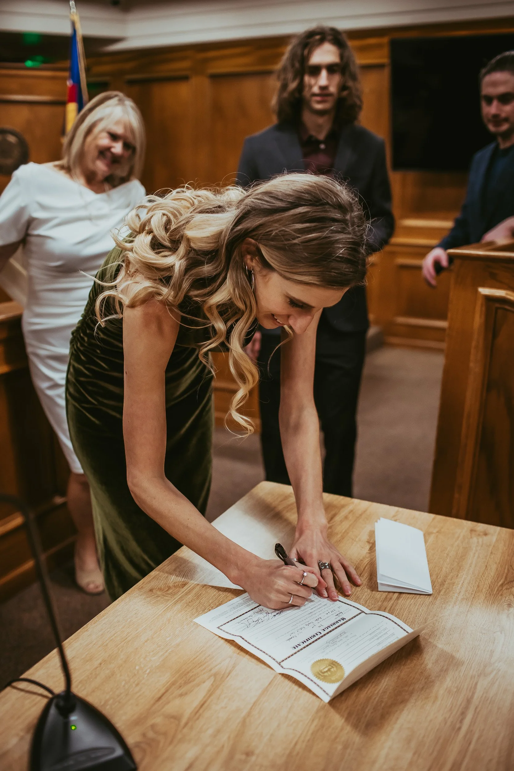 witness signing marriage license after courthouse wedding in boulder, colorado