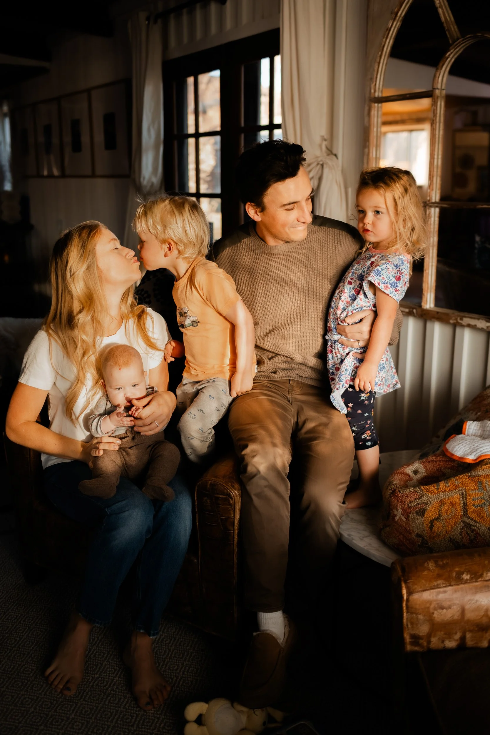 Relaxed family of five gathered on the couch for story time during a December in-home photo session