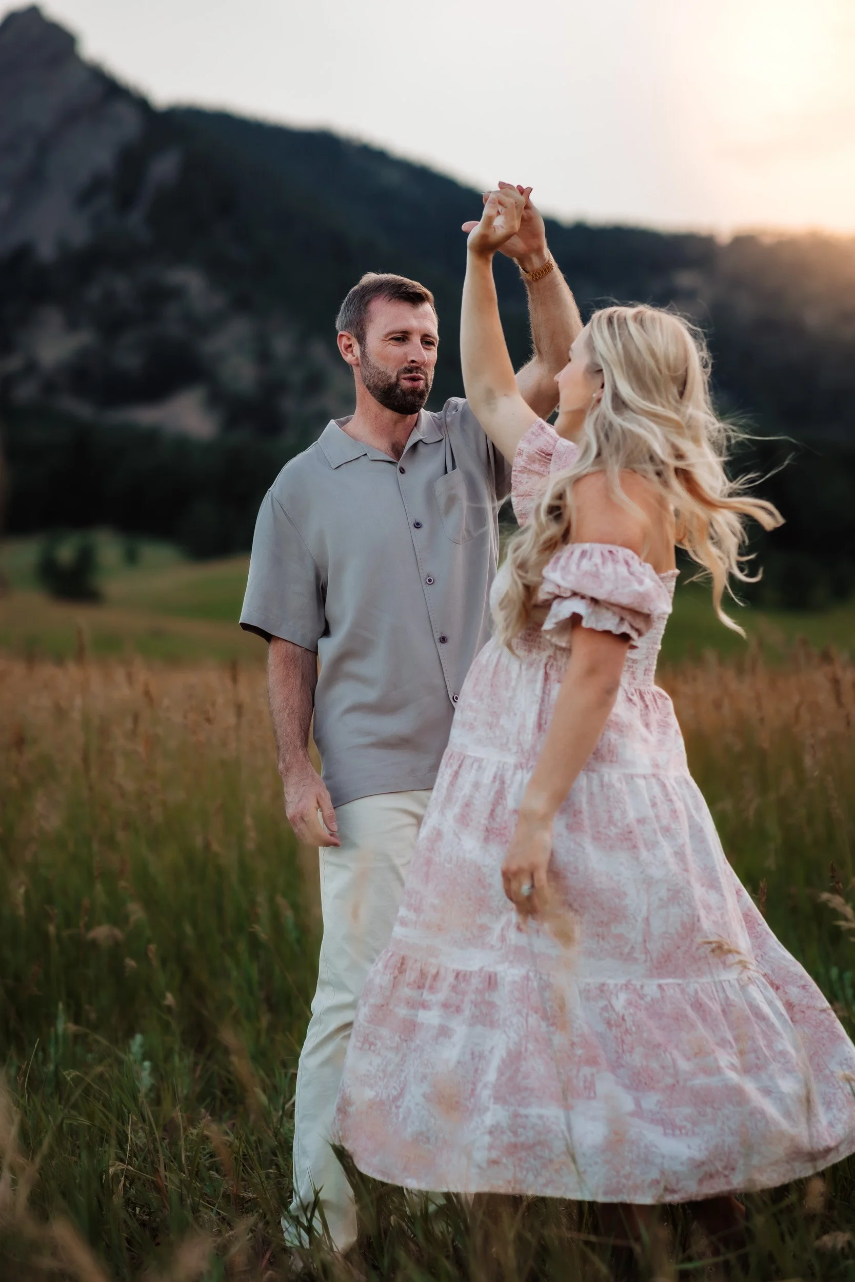 Pekabu twirling in her feminine dress while David watches lovingly during golden hour