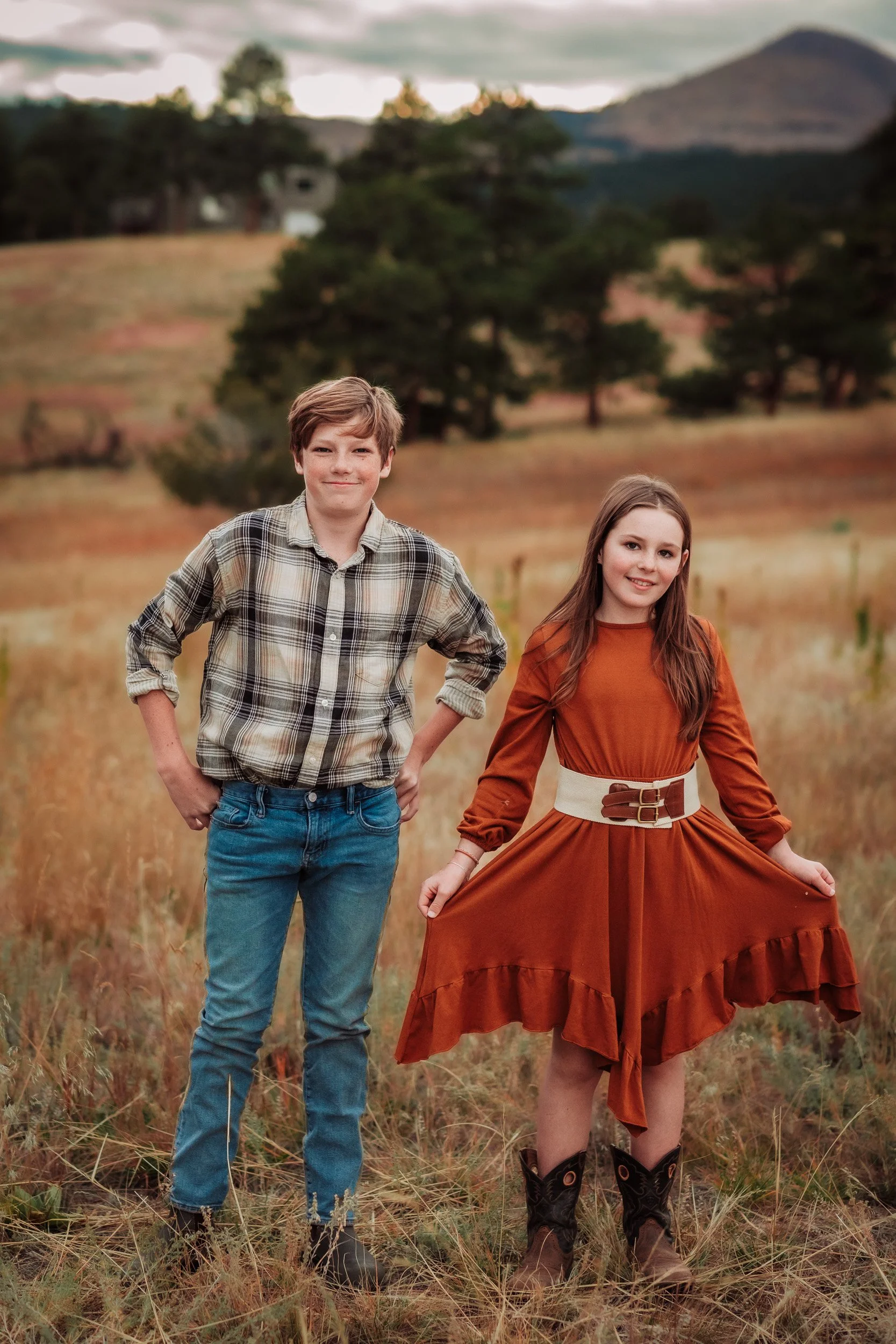 Teen siblings standing in rolling hills at Betasso Preserve in autumn