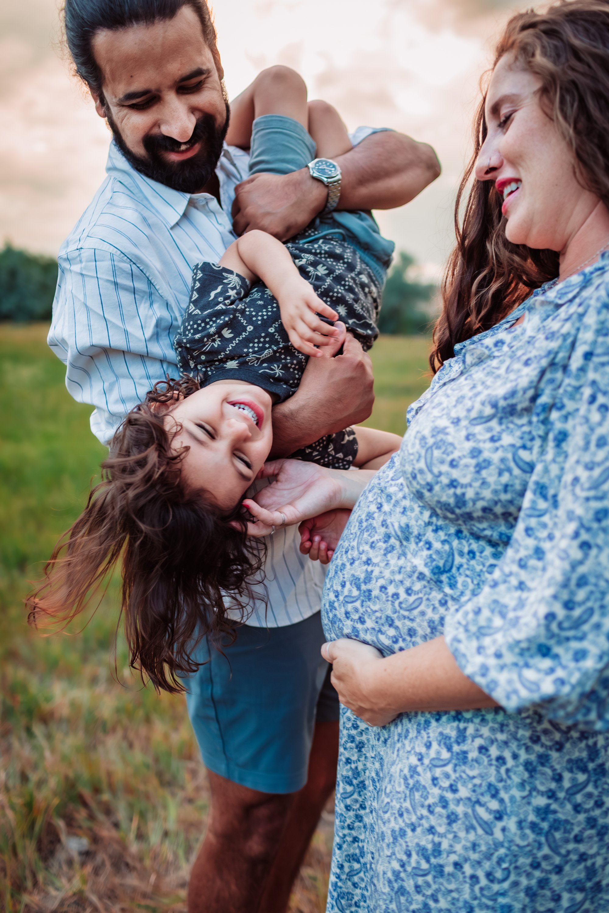 Family of three together in a Boulder field before welcoming their second baby
