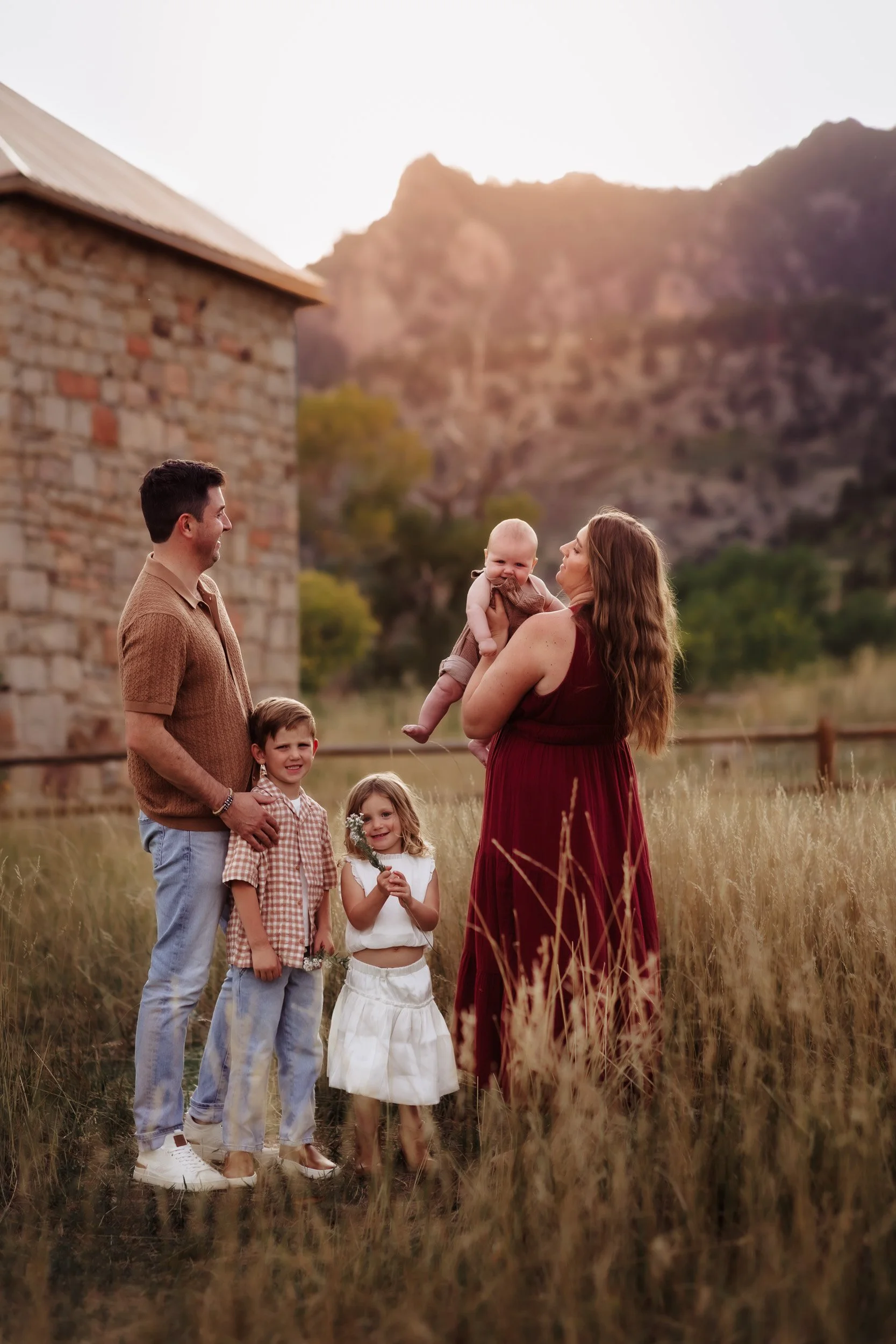 Family portrait in tall grass at South Mesa Trailhead during golden hour