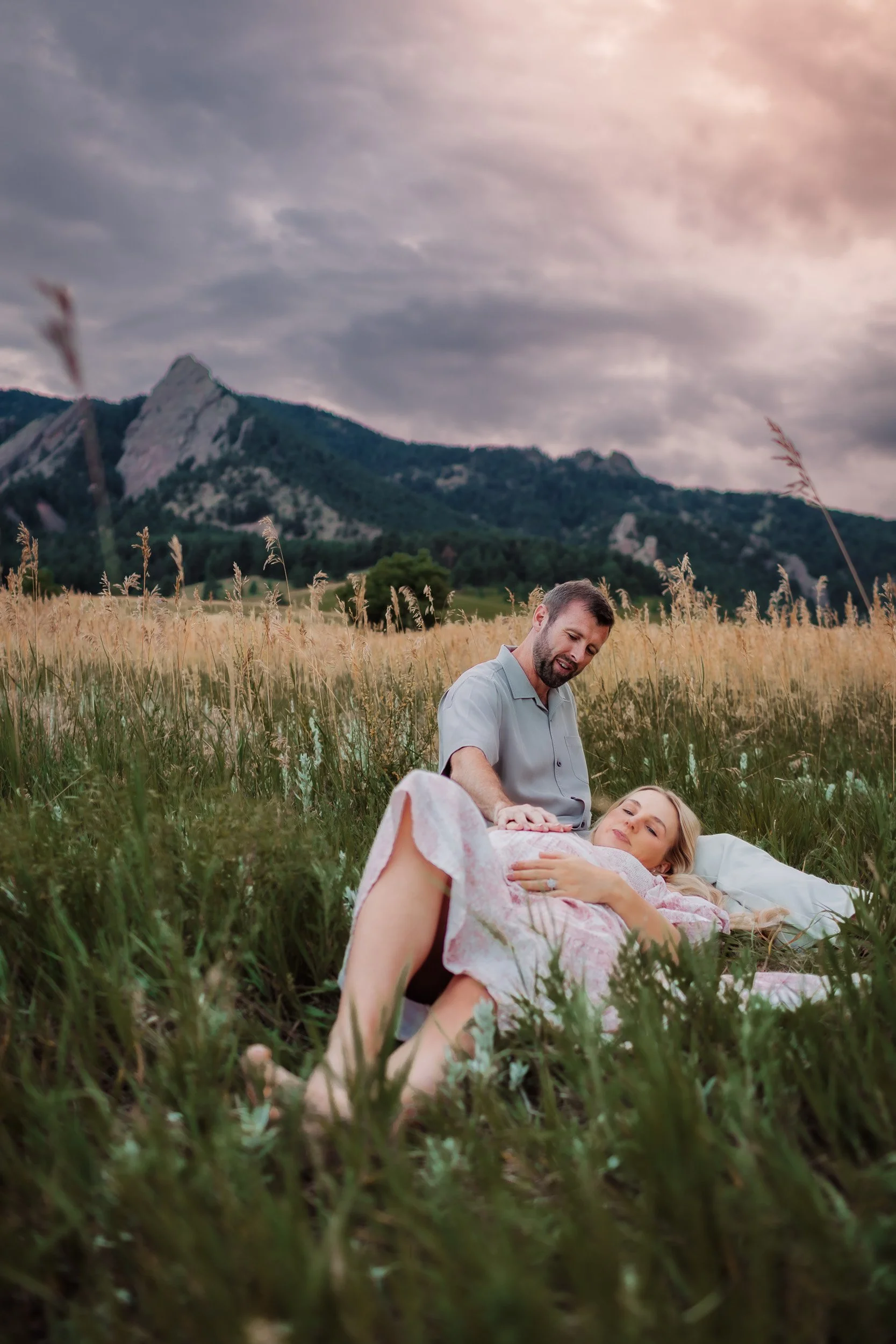 Intimate moment of Pekabu and David embracing in the grassy fields of Boulder, CO