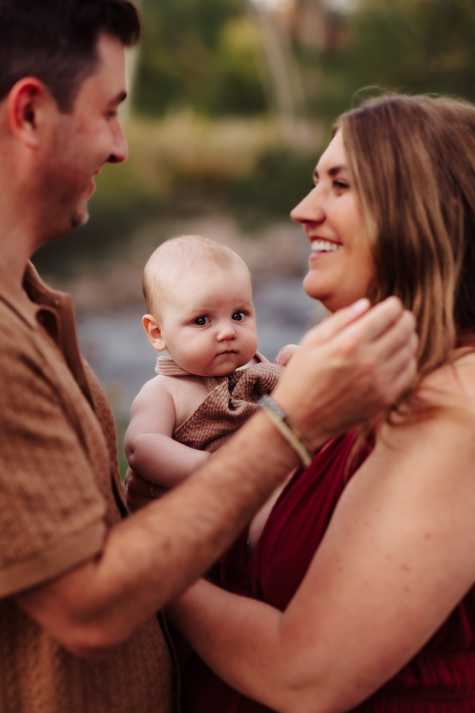 Close up of baby framed by parents at South Mesa Trailhead during golden hour