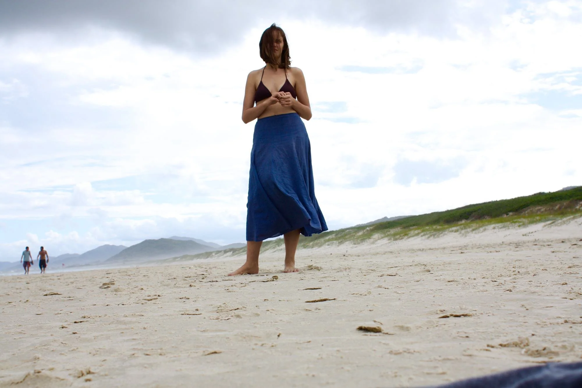 Young woman standing on beach in Florianopolis  before a storm rolls in. 