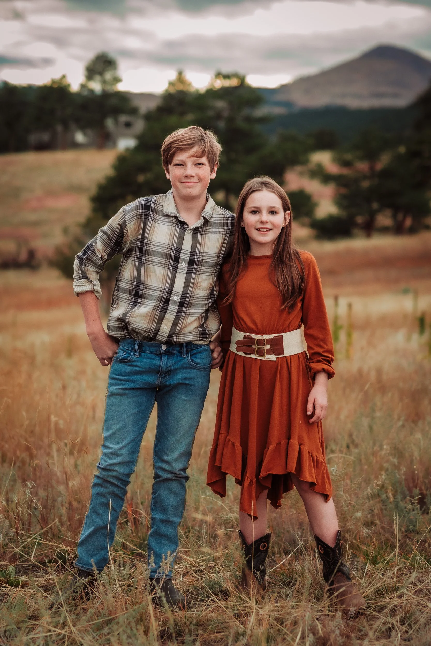 Teen siblings standing in rolling hills at Betasso Preserve in autumn