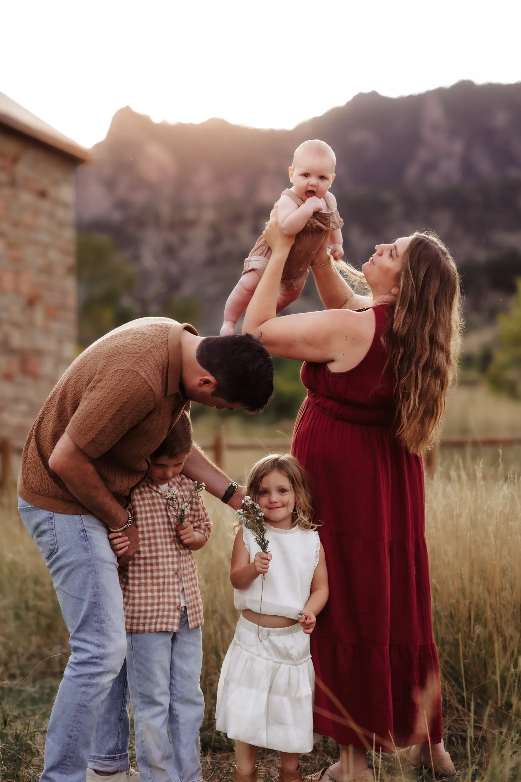 Family portrait in tall grass at South Mesa Trailhead during golden hour