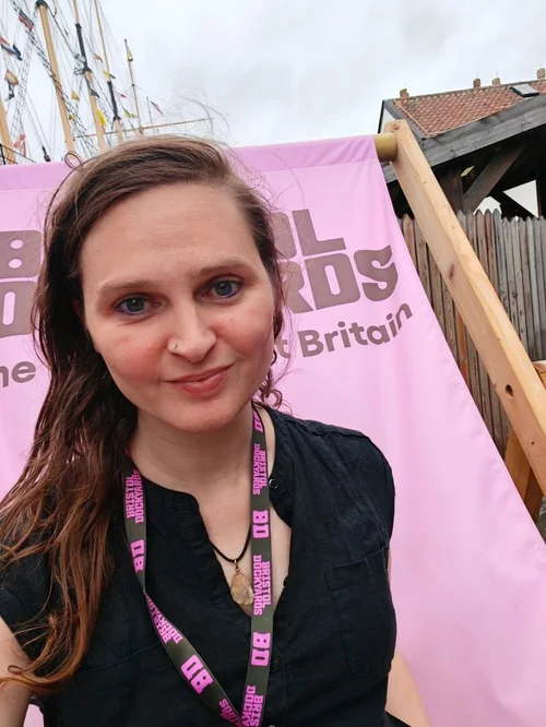 Jocelyn Burnham at Bristol Dockyards, in front of a pink banner and wearing a Bristol Dockyards lanyard.