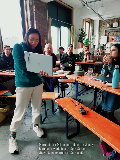 A workshop participant shows off their game to a small audience