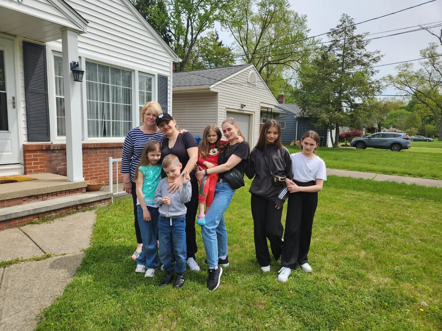 Family standing on a front lawn