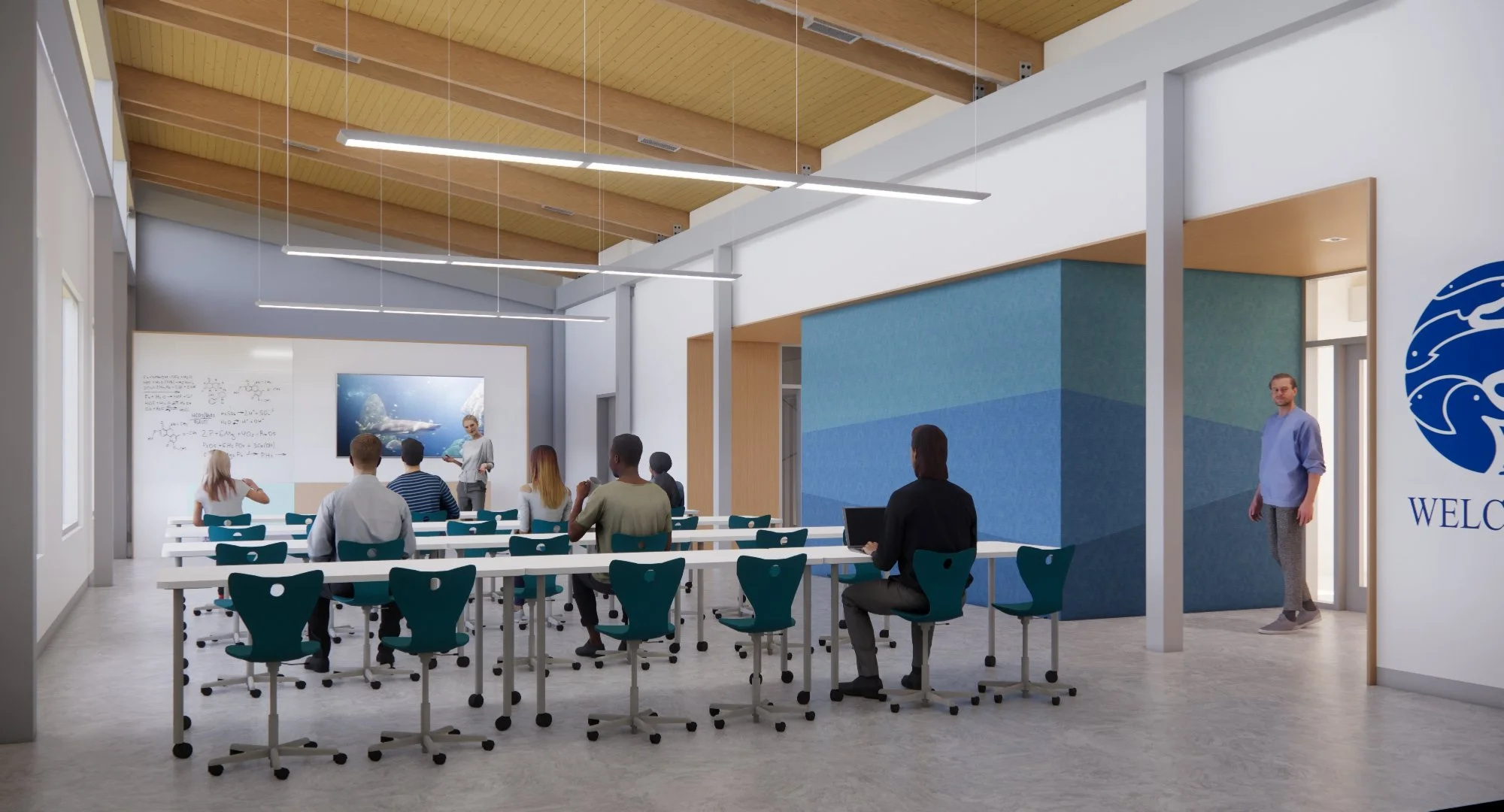 A classroom or conference room with students and a teacher. The teacher is at the front, near a screen showing an underwater scene, with whiteboards and scientific diagrams on the walls. Students sit at white desks with teal chairs, some taking notes or listening attentively.