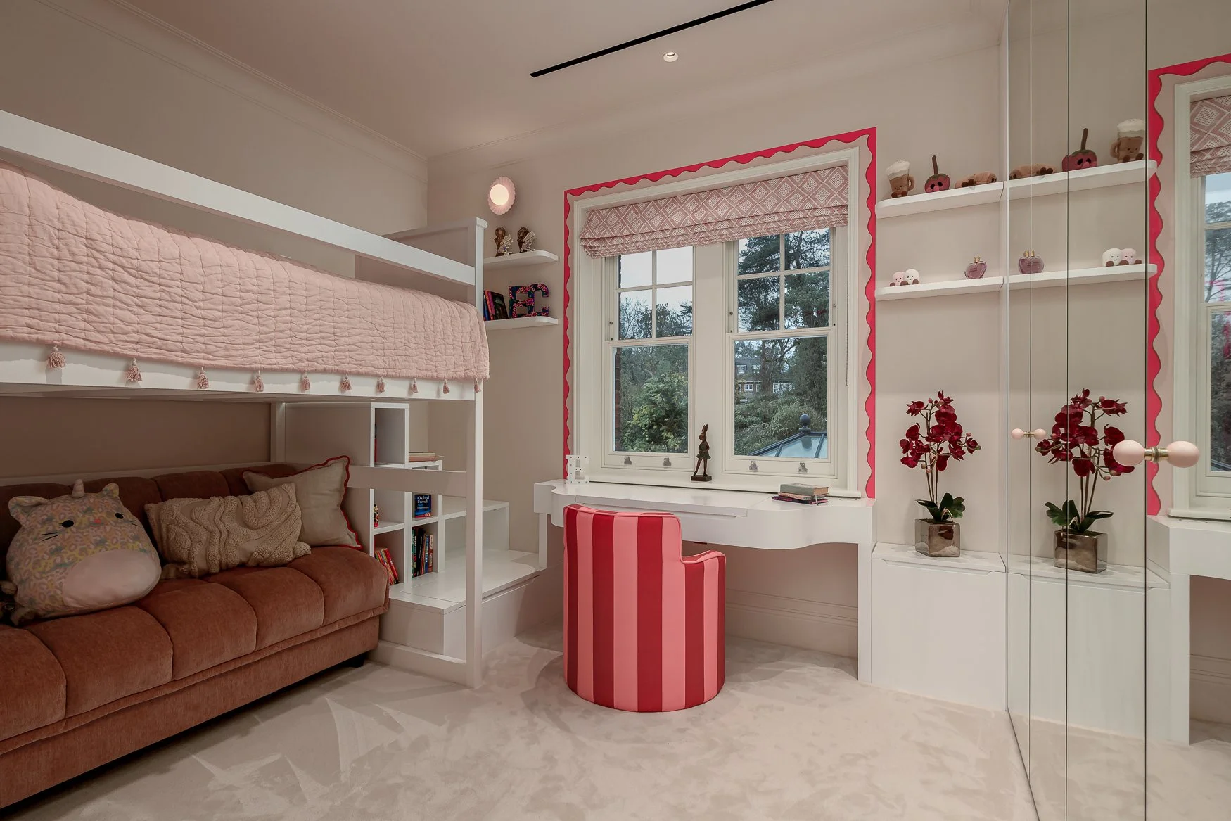 Children’s bedroom detail with playful pink furniture, patterned wallpaper and decorative styling.