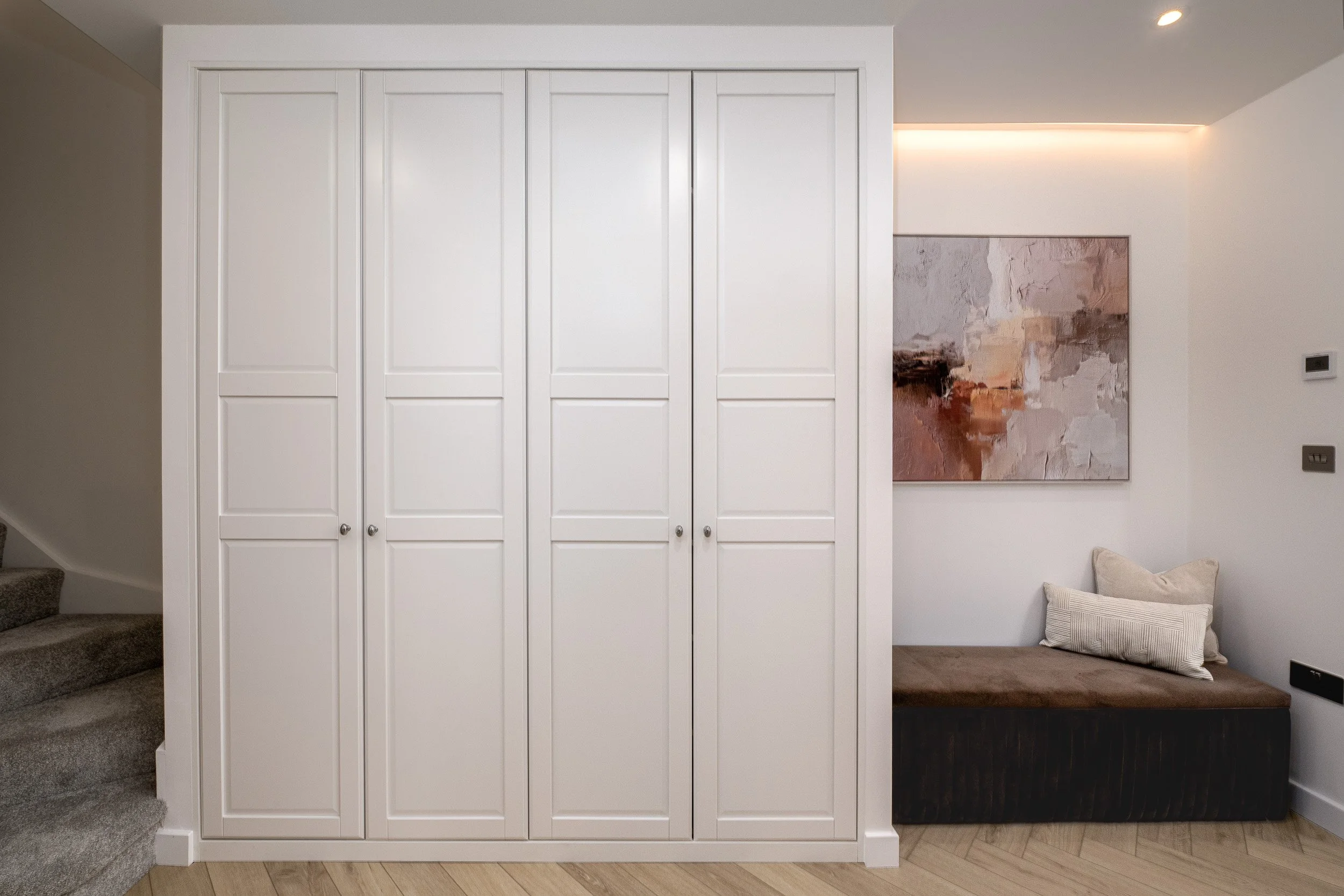 Photo of a hallway, seating bench and the integrated wardrobe