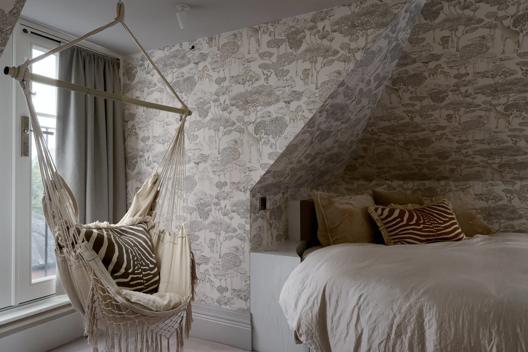 Grey wallpappered bedroom with swing chair