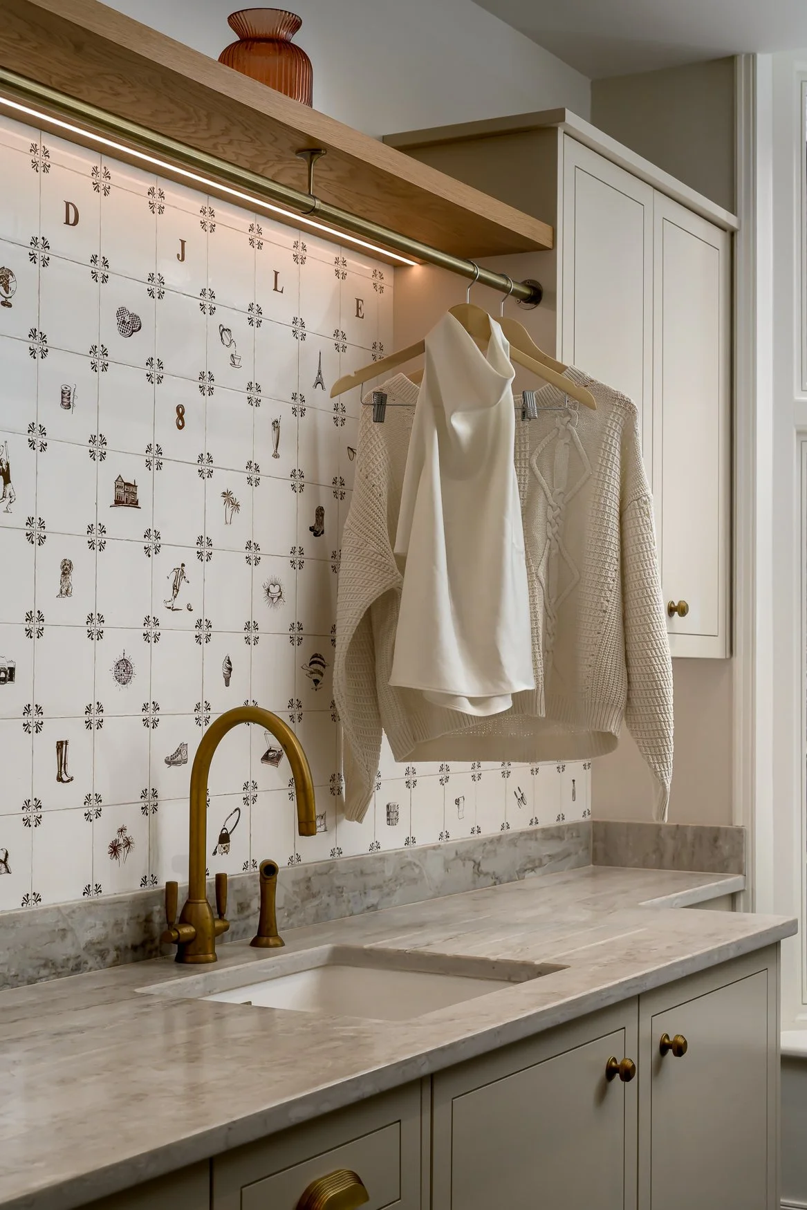 Laundry room with handmade bespoke tiles, brass tap and marble worktop.