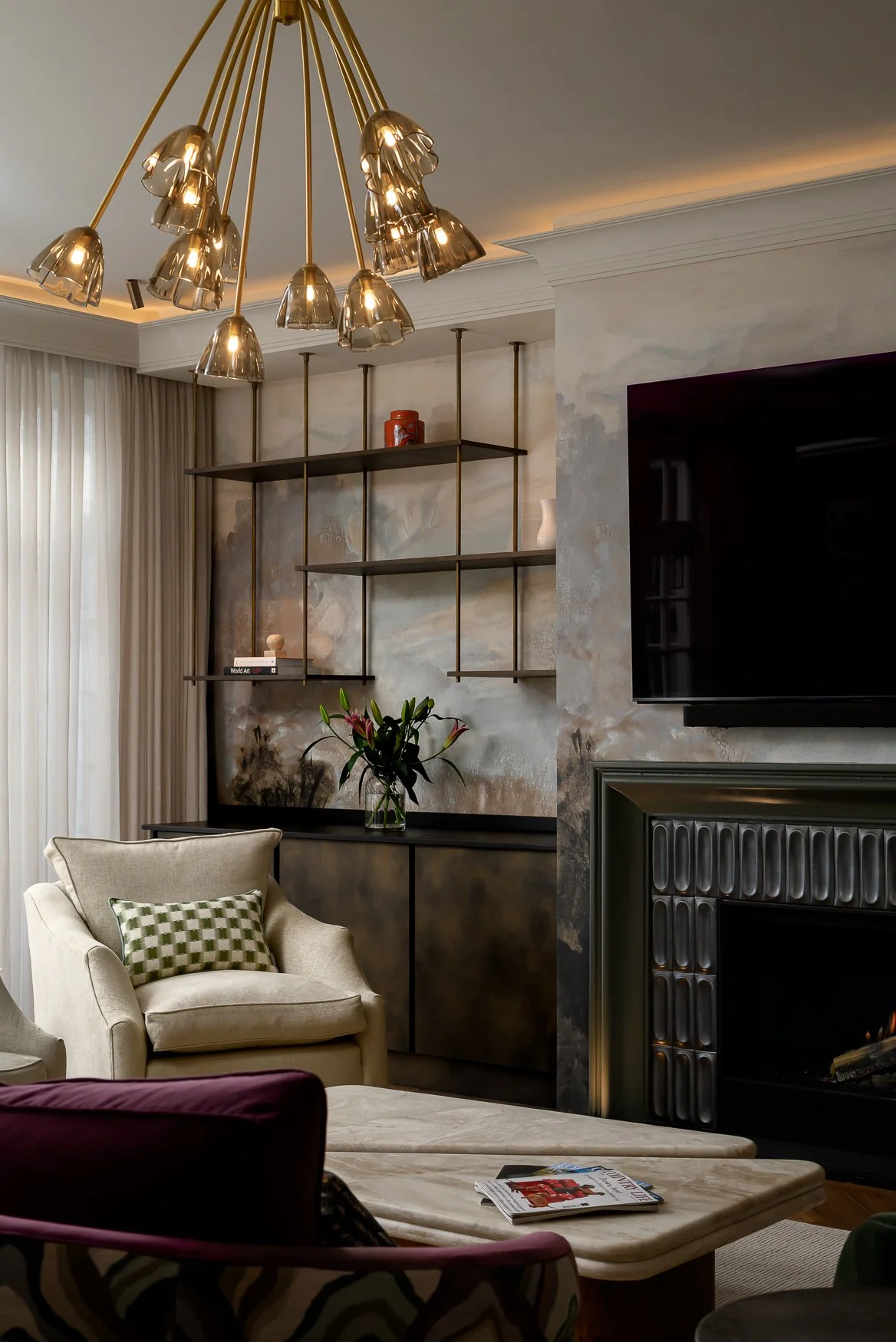 Living room fireplace, armchair and patterned soft furnishings in a Barnet family home.