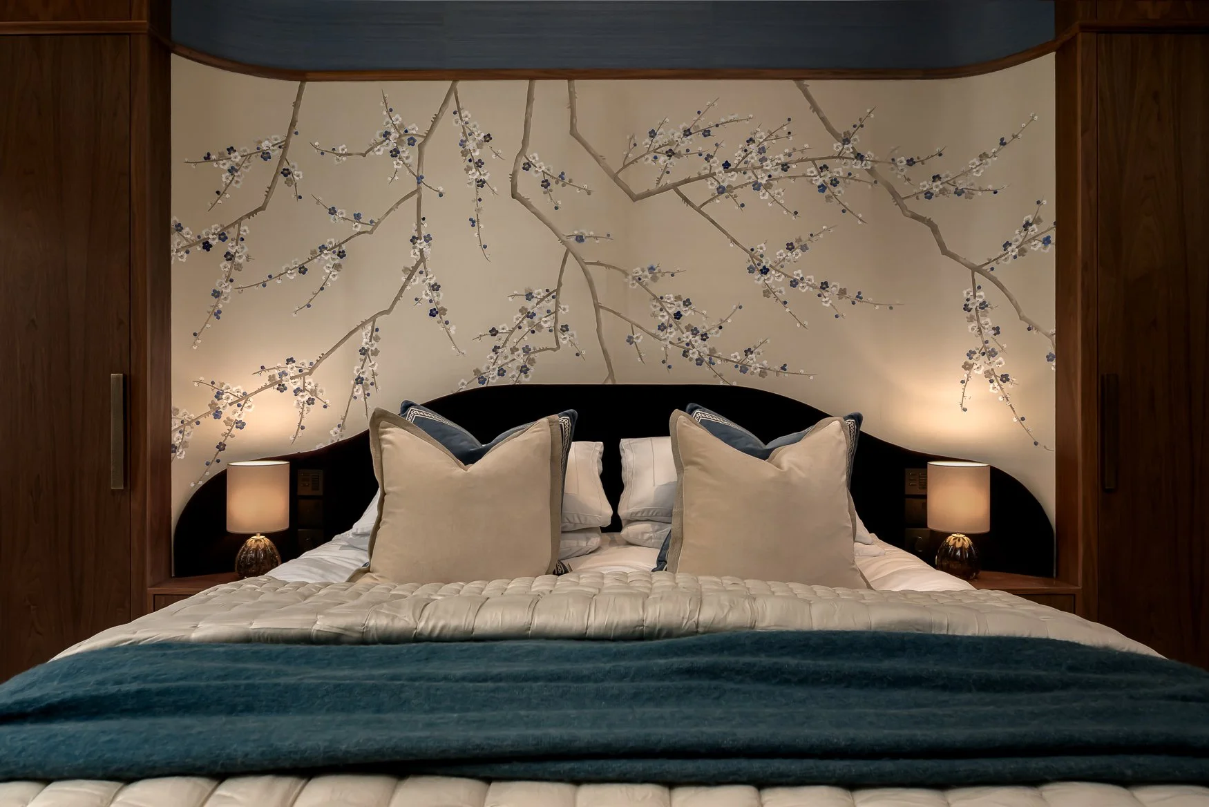 Close-up of cushions, bedding and hand-finished wallcovering in a luxury bedroom.