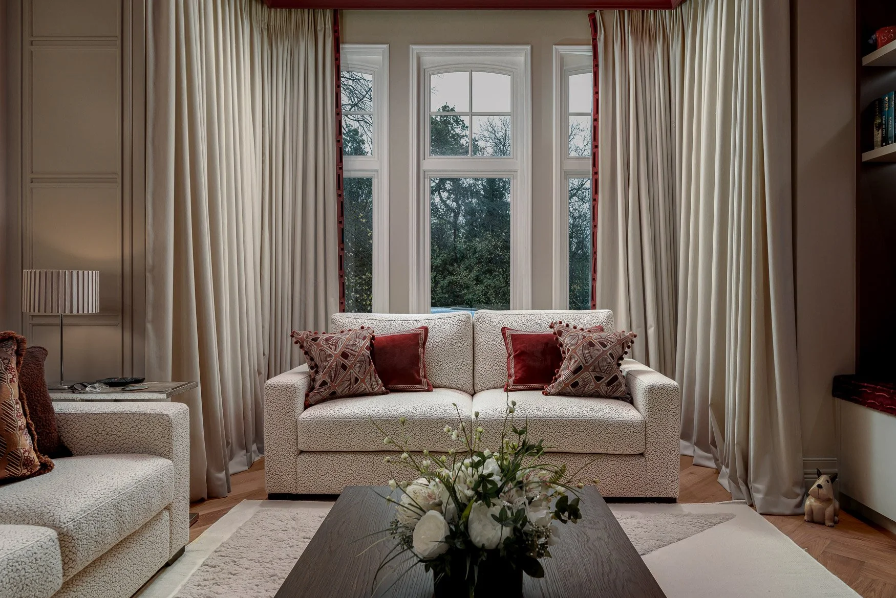 Layered living room with patterned fabrics, warm lighting and bespoke joinery by JAM Design Works.