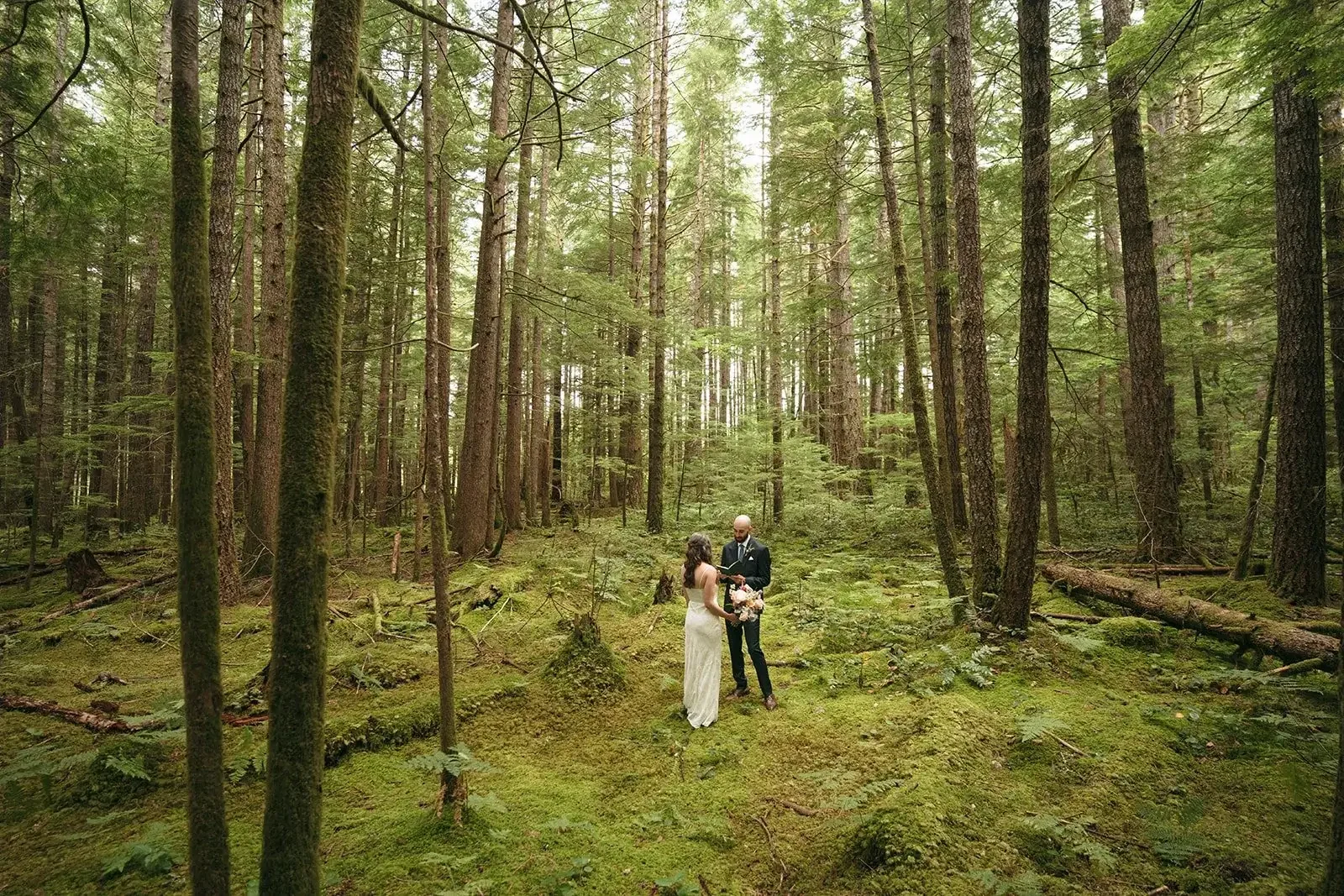 bride and groom exchange private vows in forest