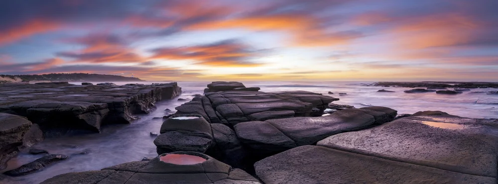 Rocky coastline under a colourful sunrise sky