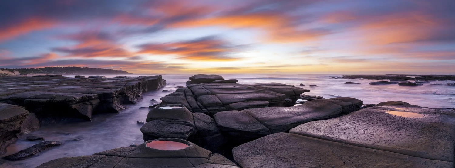 A rocky shoreline at sunrise