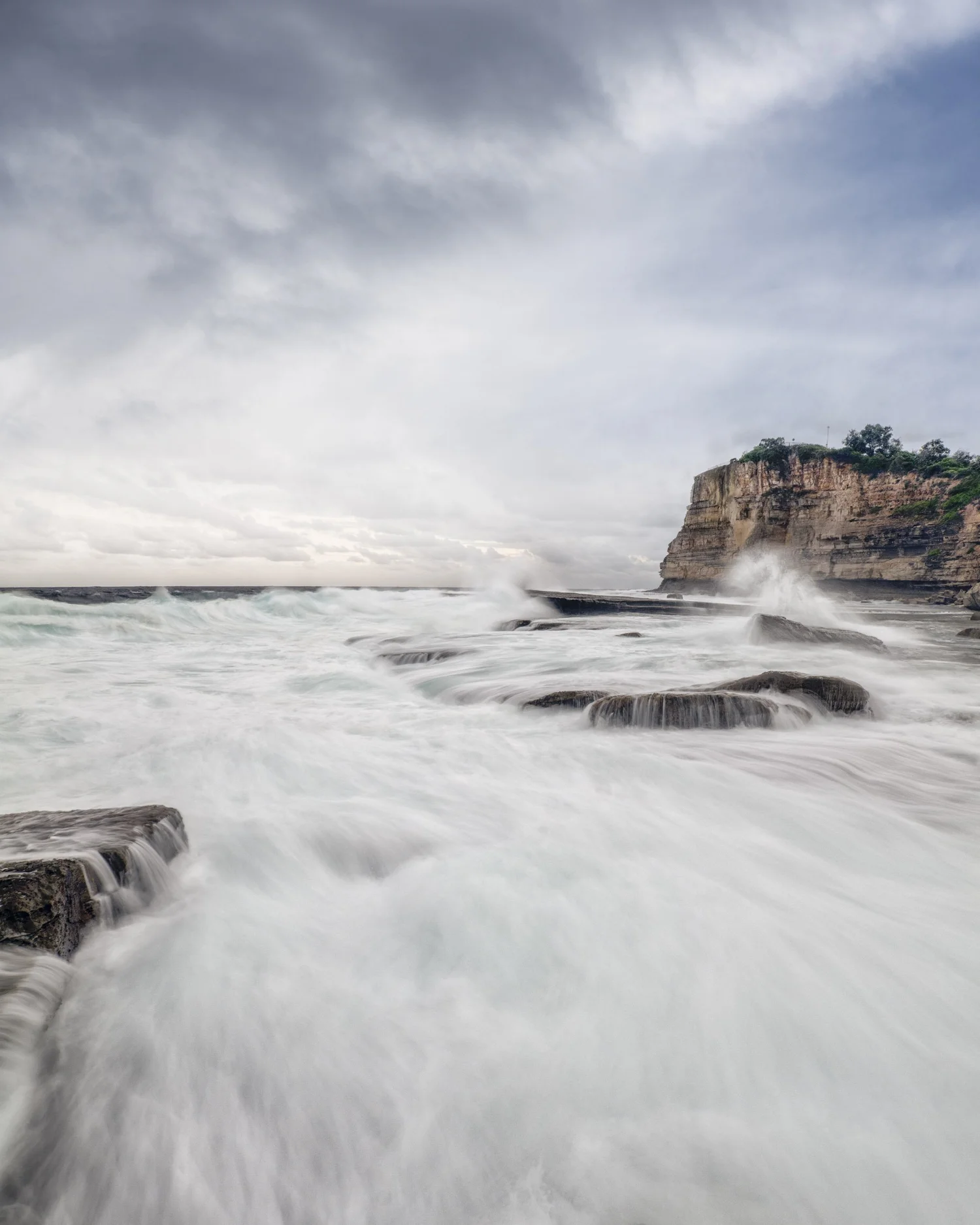 Long exposure of waves washing over coastal rocks