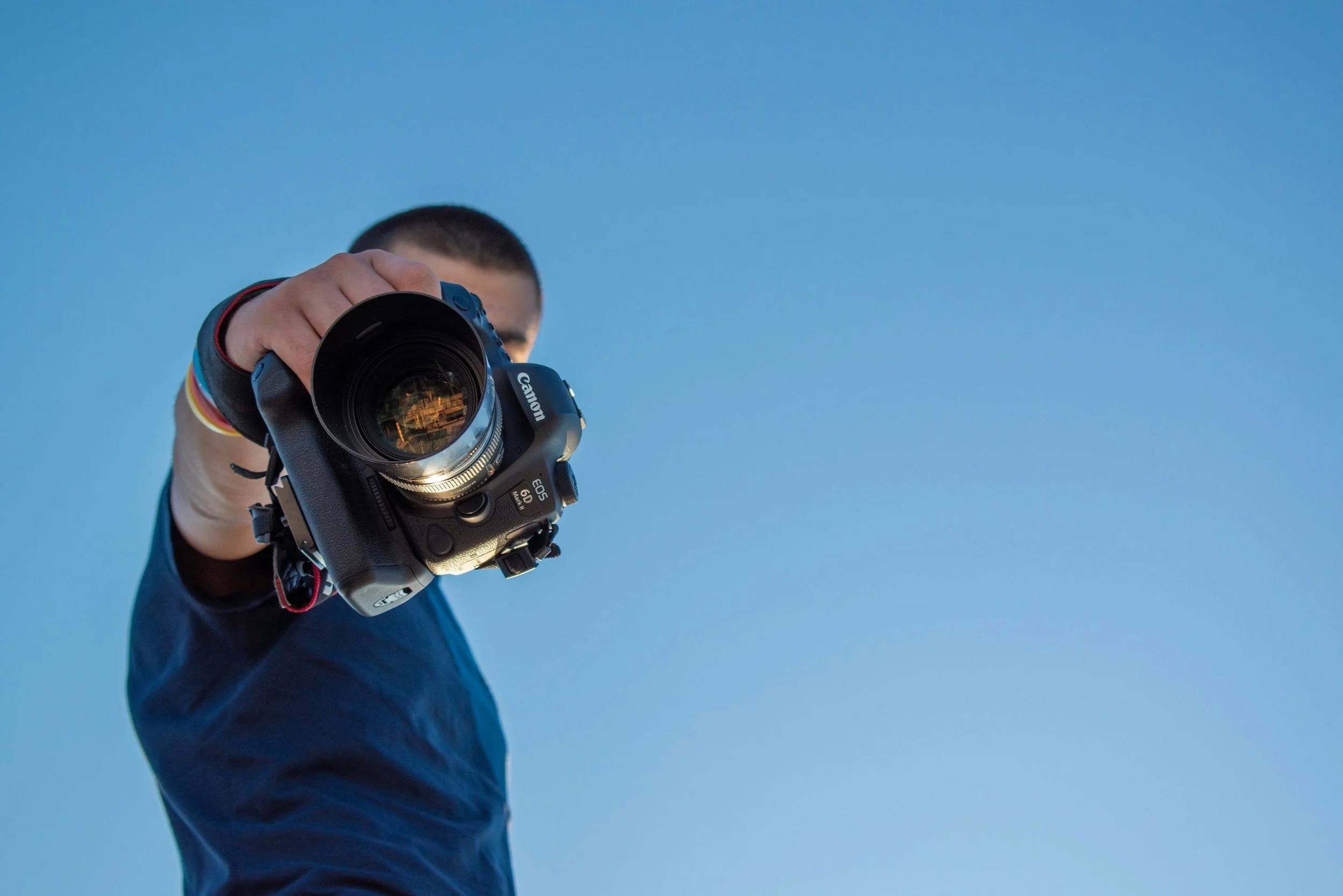 A photographer holding a camera towards the viewer