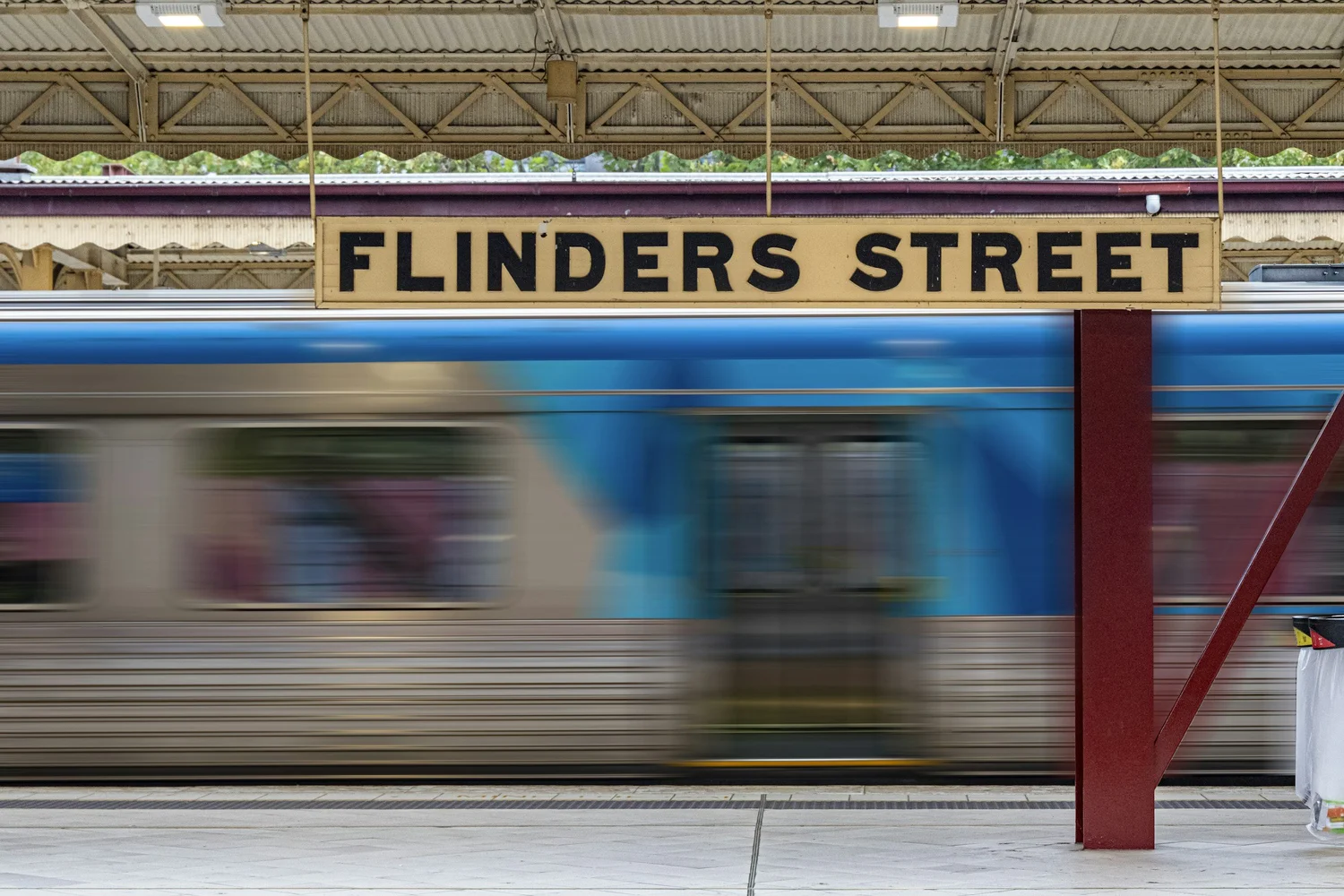 Flinders Street Station with a train passing in the evening