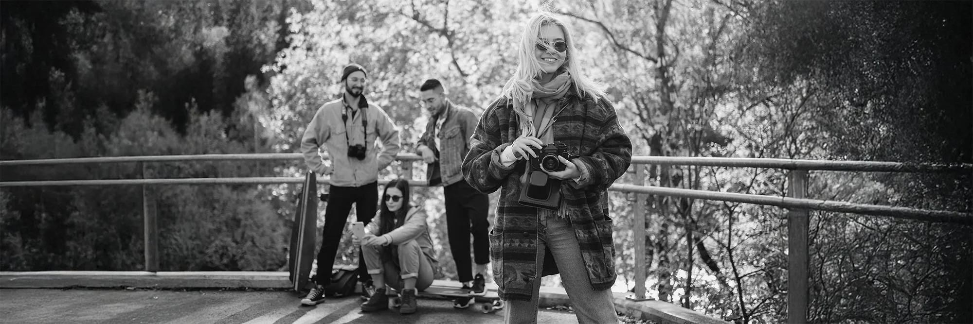 A black-and-white photograph of a small group of photographers working together on location.
