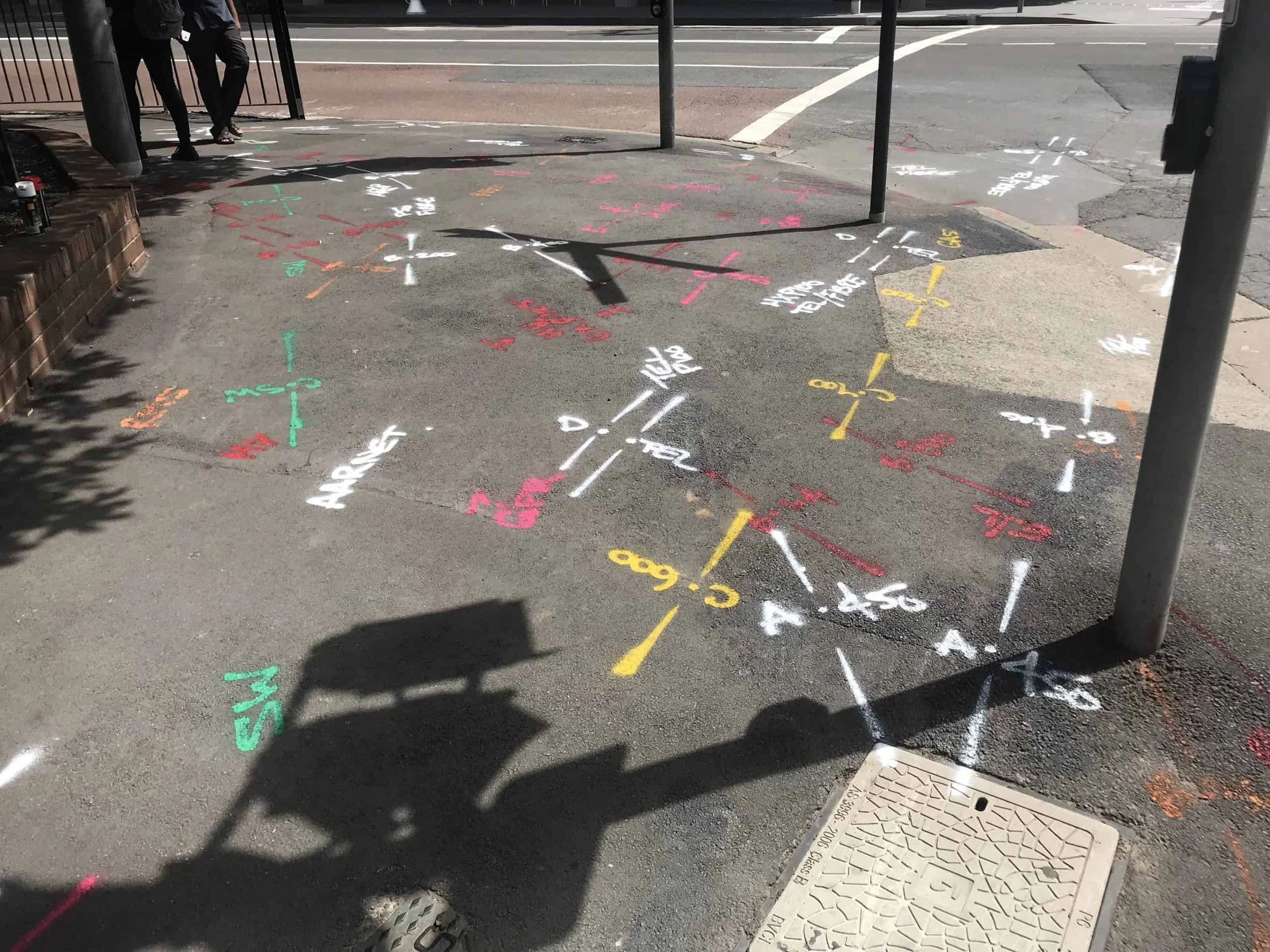 Underground utility marking on pavement showing located services before excavation