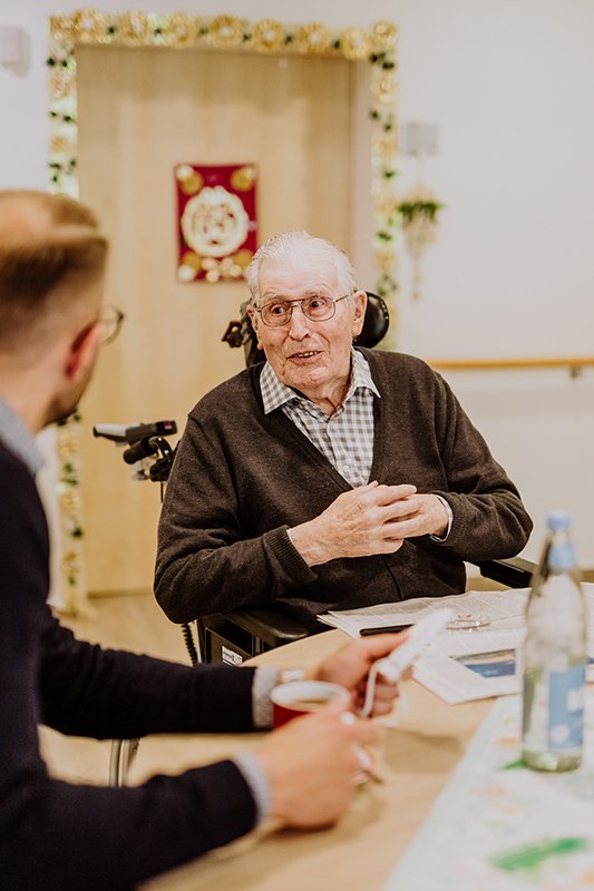 Ulrich Zerhusen im Gespräch mit einem Bewohner einer Pflegeeinrichtung – persönliche Nähe und Verständnis für die Pflegepraxis