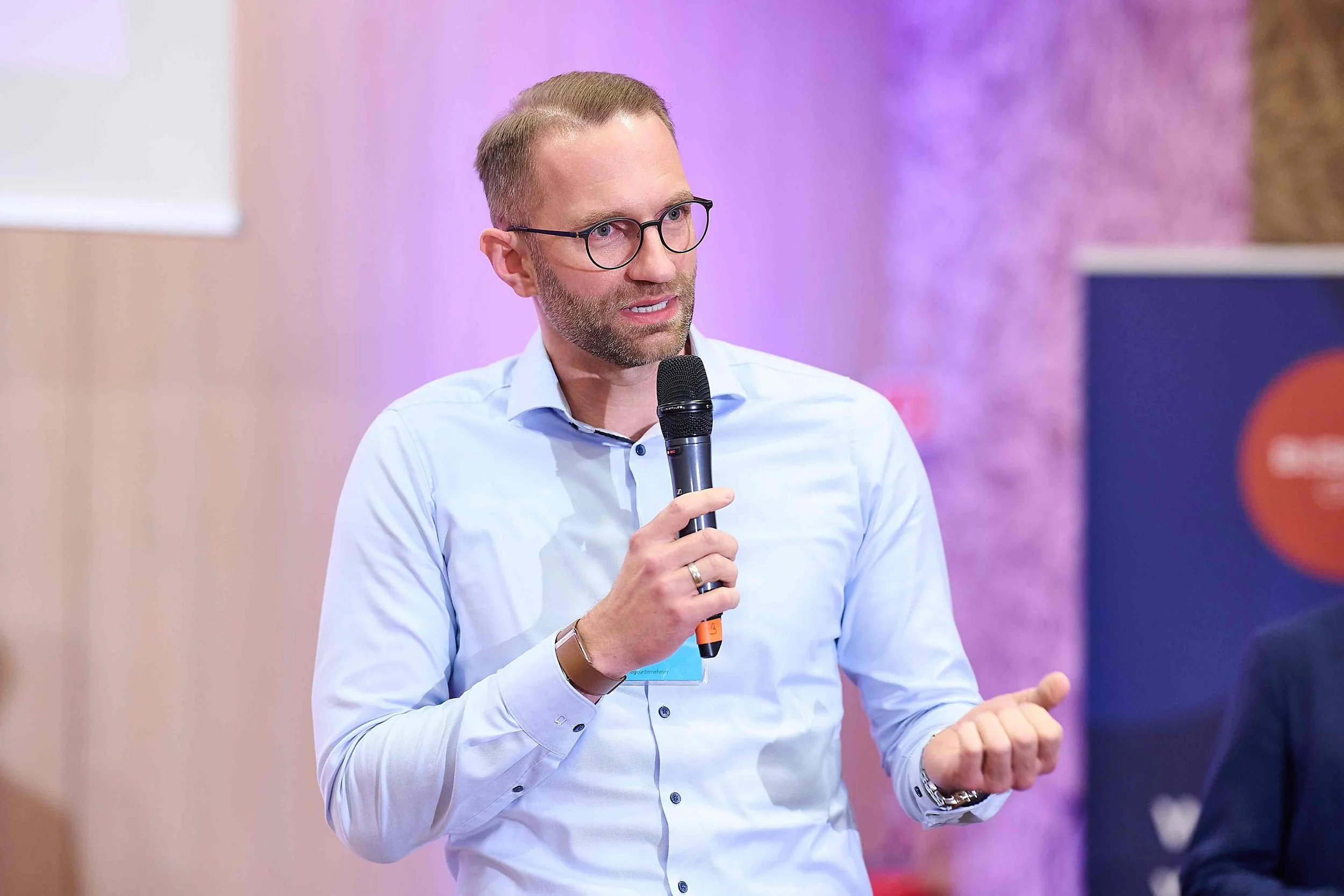 Ulrich Zerhusen spricht als Pflege-Speaker mit Mikrofon auf einer Veranstaltung über die Zukunft der Pflege.