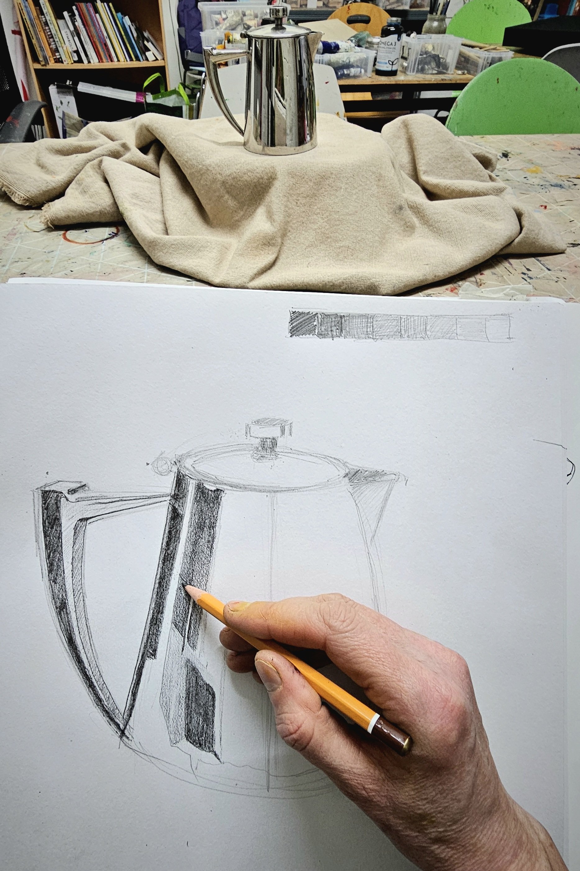 hand holding pencil drawing coffee pot.jpg
