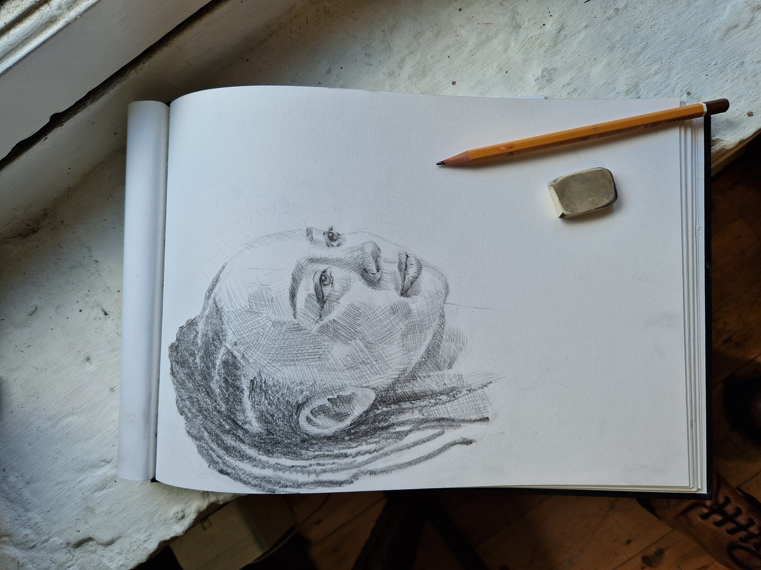 sketchbook with drawing of girl with braids in pencil.jpg